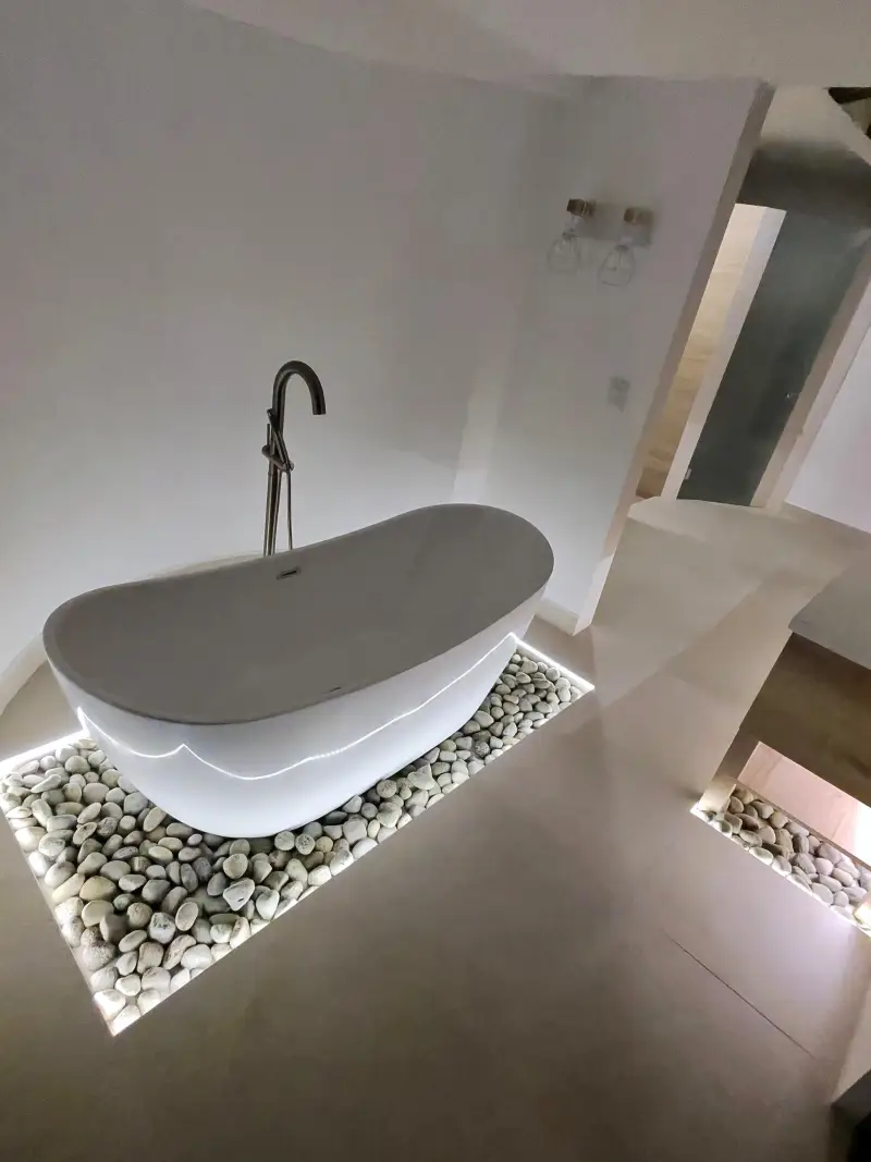 Tina exenta con iluminación y piedras decorativas